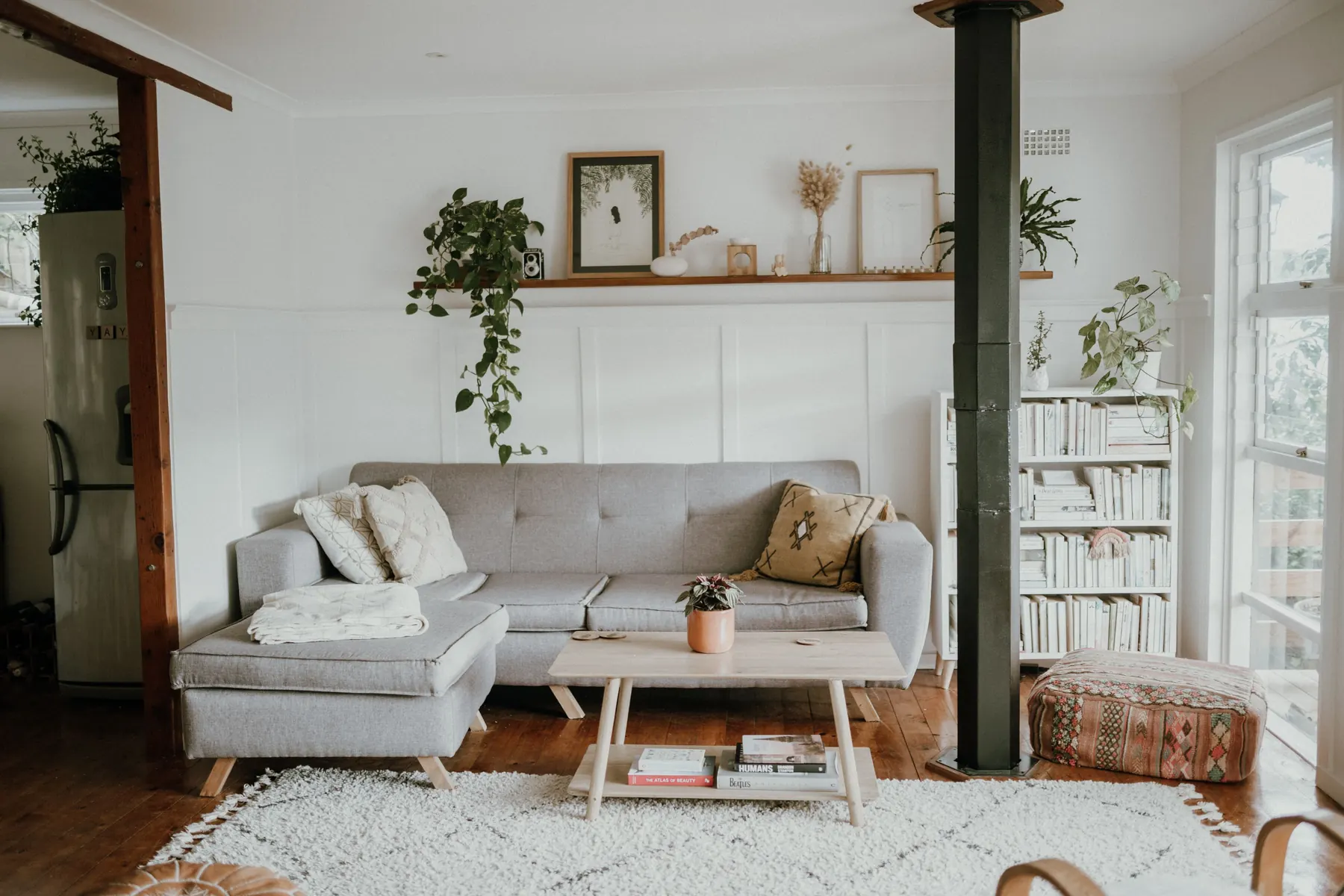 Lys stue med sofa, bord og bokhylle